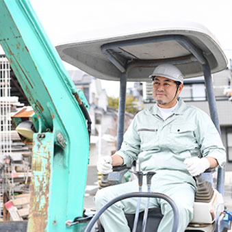 工事現場で重機に乗る男性