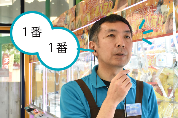 イヤホンでアナウンスを聞くスタッフ